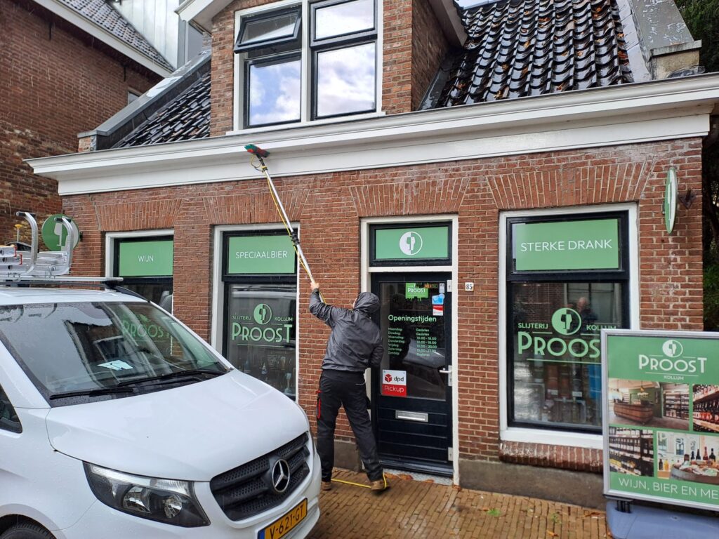 Glasbewassing van een winkelpui in Kollum