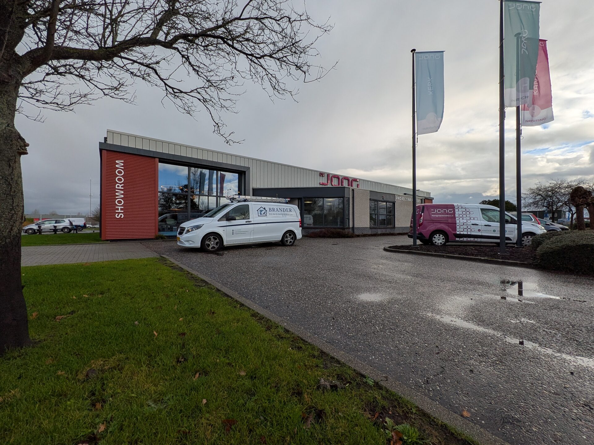 Bedrijfsbus van Reinigingsservice Brander bij een showroom
