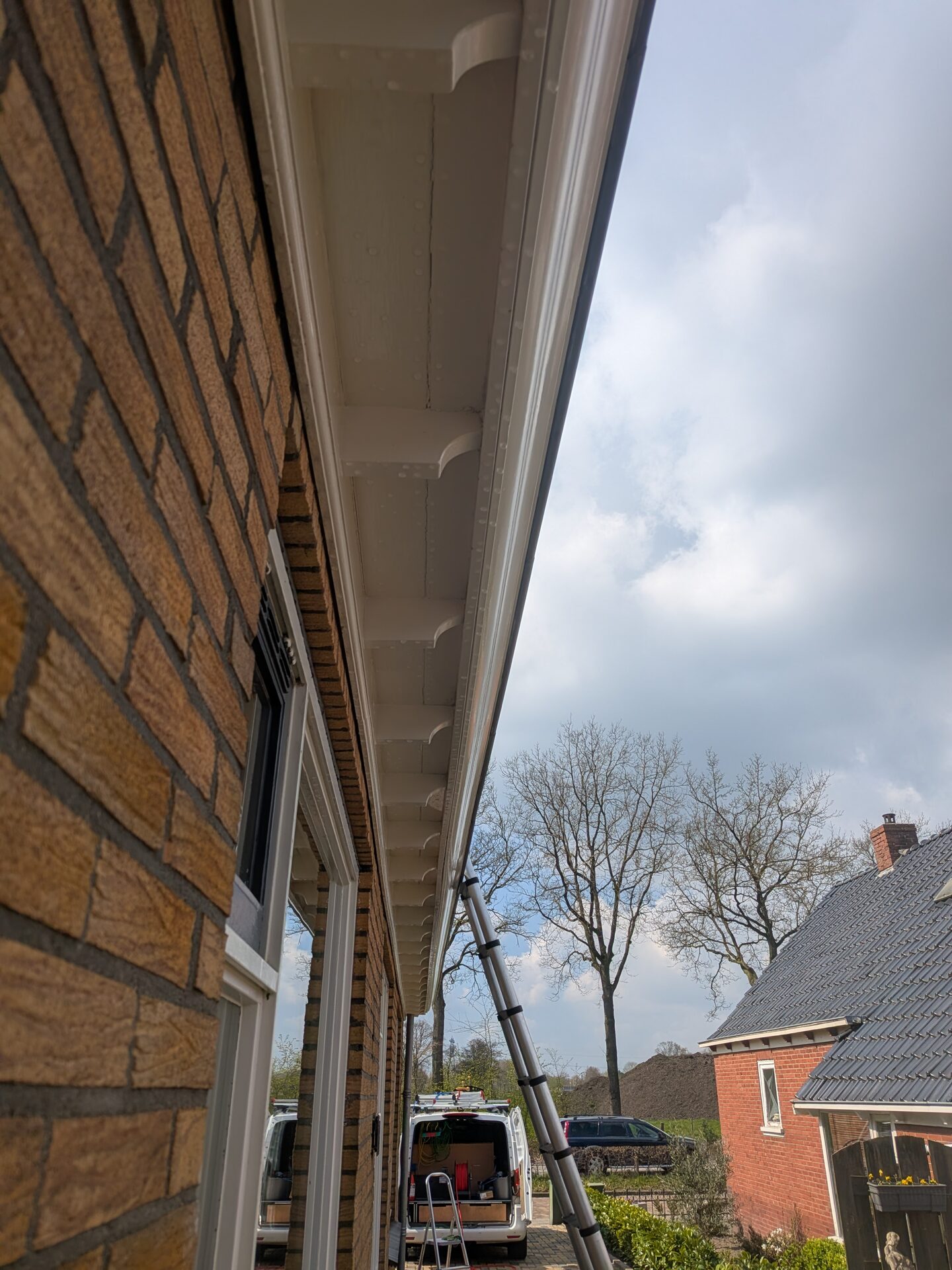 Dakgootreiniging met ladder aan een woning