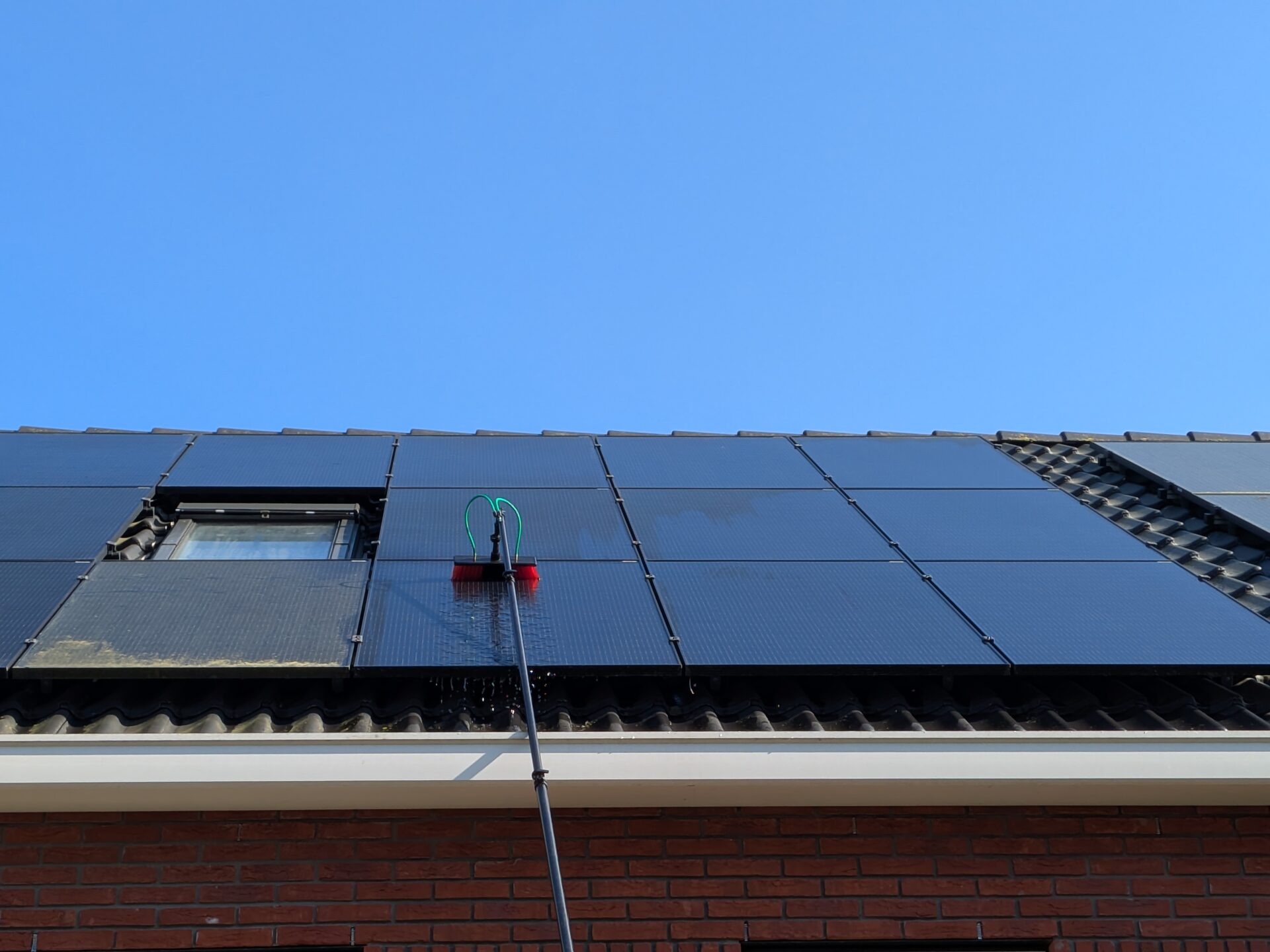 Zonnepanelen reinigen met een telescoopborstel en osmosewater